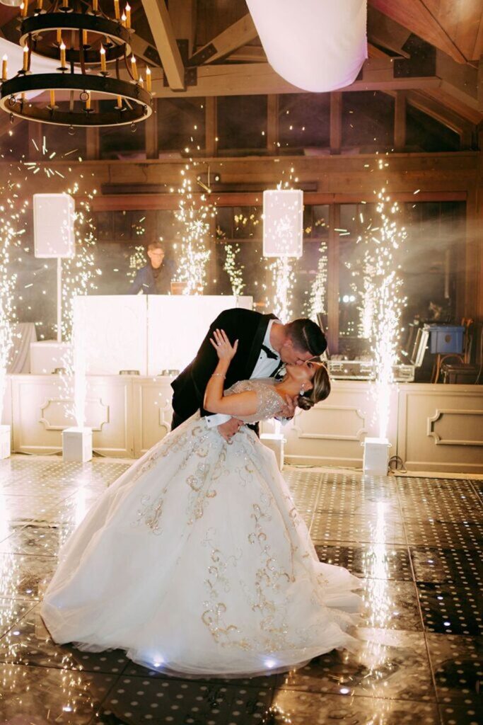 Newly wed couple kissing with sparklers in the background