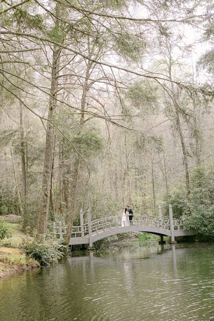 Bride and groom sharing private moment on bridge over water