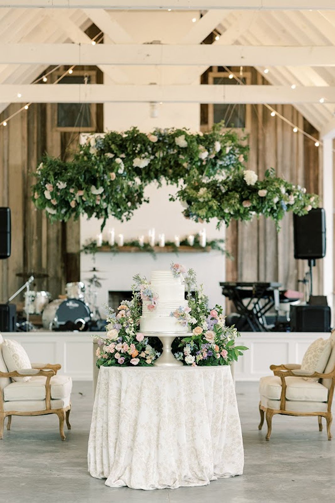 Wedding cake with floral elements sitting on decorated table