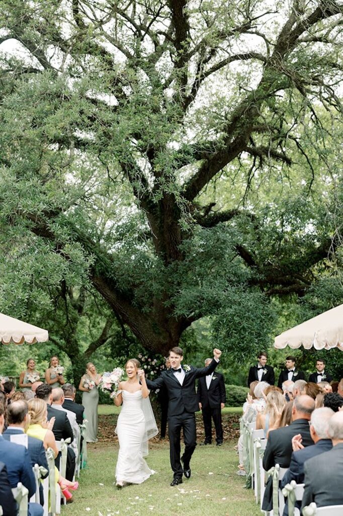 Bride and Groom cheering after wedding ceremony walking down the aisle