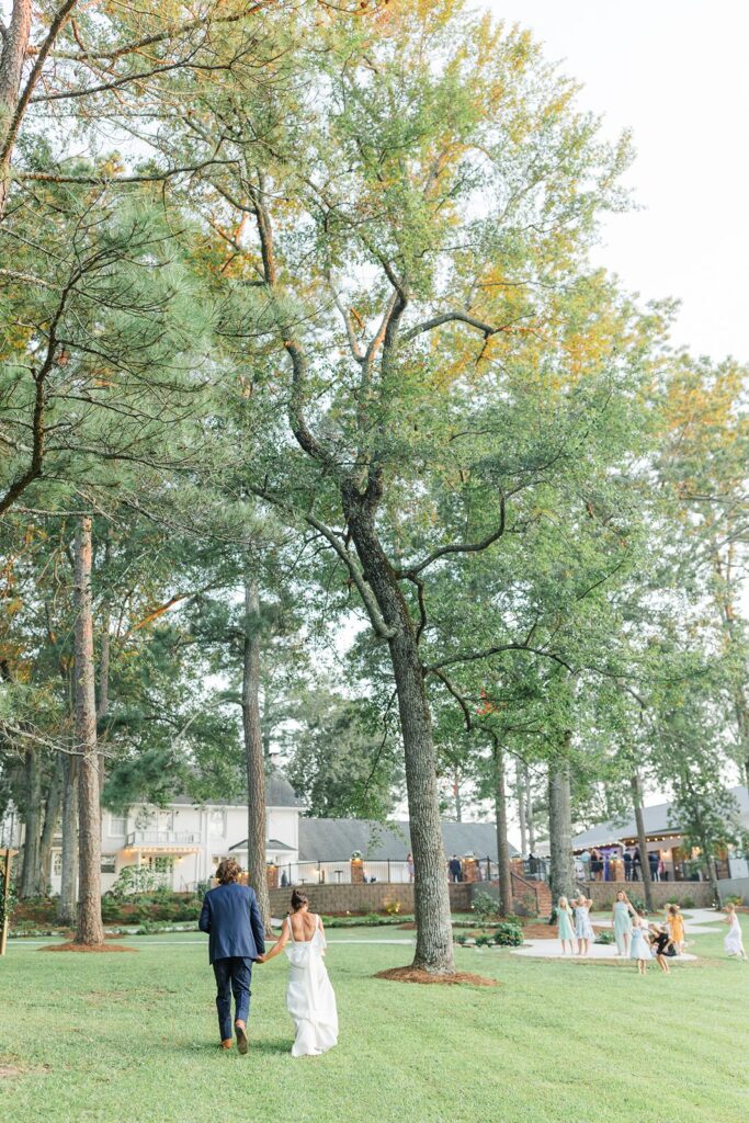 Bride and Groom walking on back lawn at Heron Hill Venue