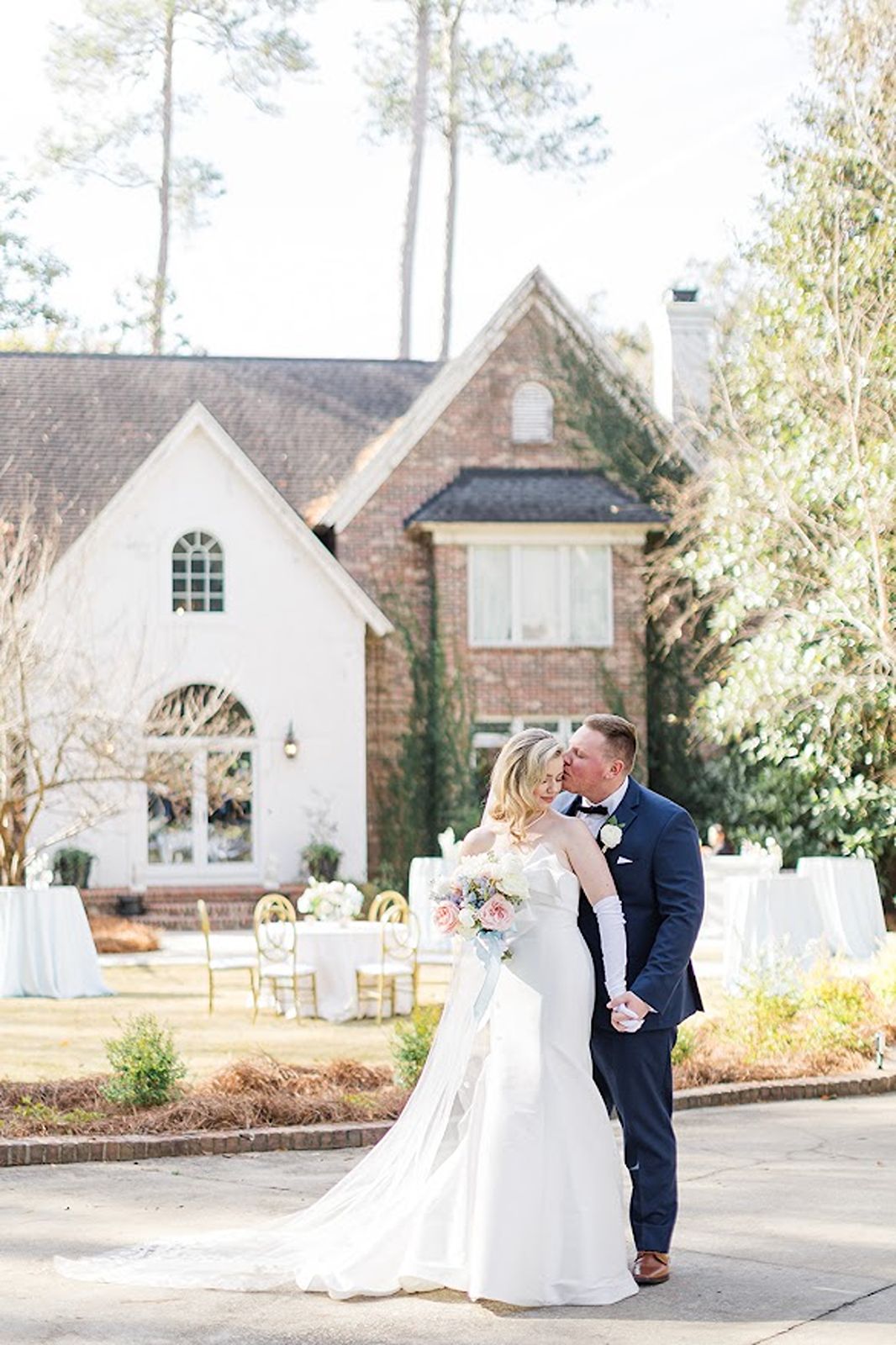 Couple posed in front of house on wedding day