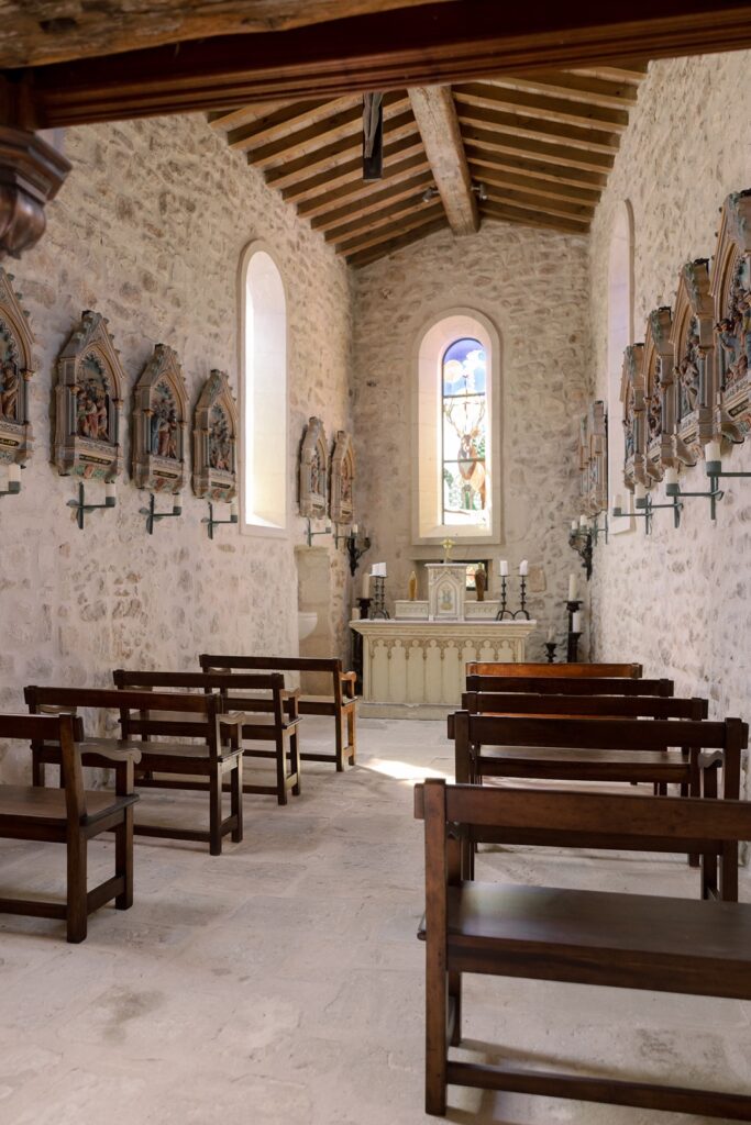 Intimate stone chapel with wooden pews, stained glass, and rustic charm, perfect for a romantic ceremony